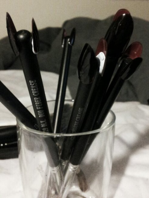 WTF?  They're cheap red pointy false nails, blue-tacked on to the end of makeup brushes, so I could paint them black.  They will be Chloe's claws.